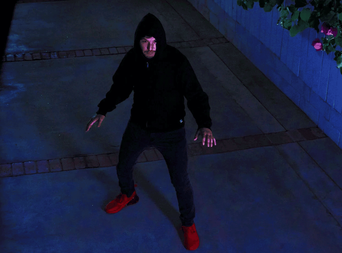 Night, person dressed in black approaching via driveway