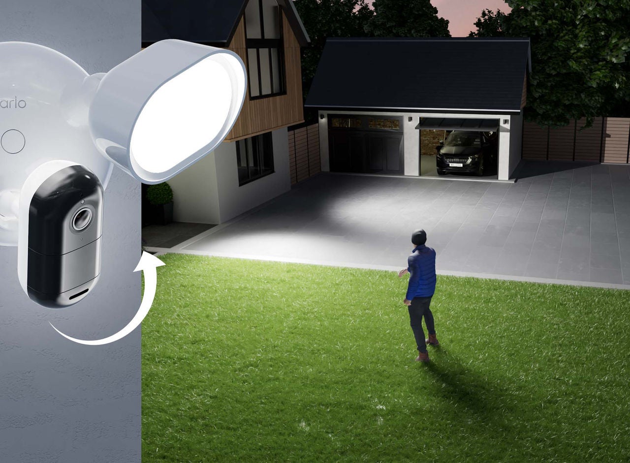 Arlo-strålkastare kopplad till ett hus fångar en man utanför en öppen garageport