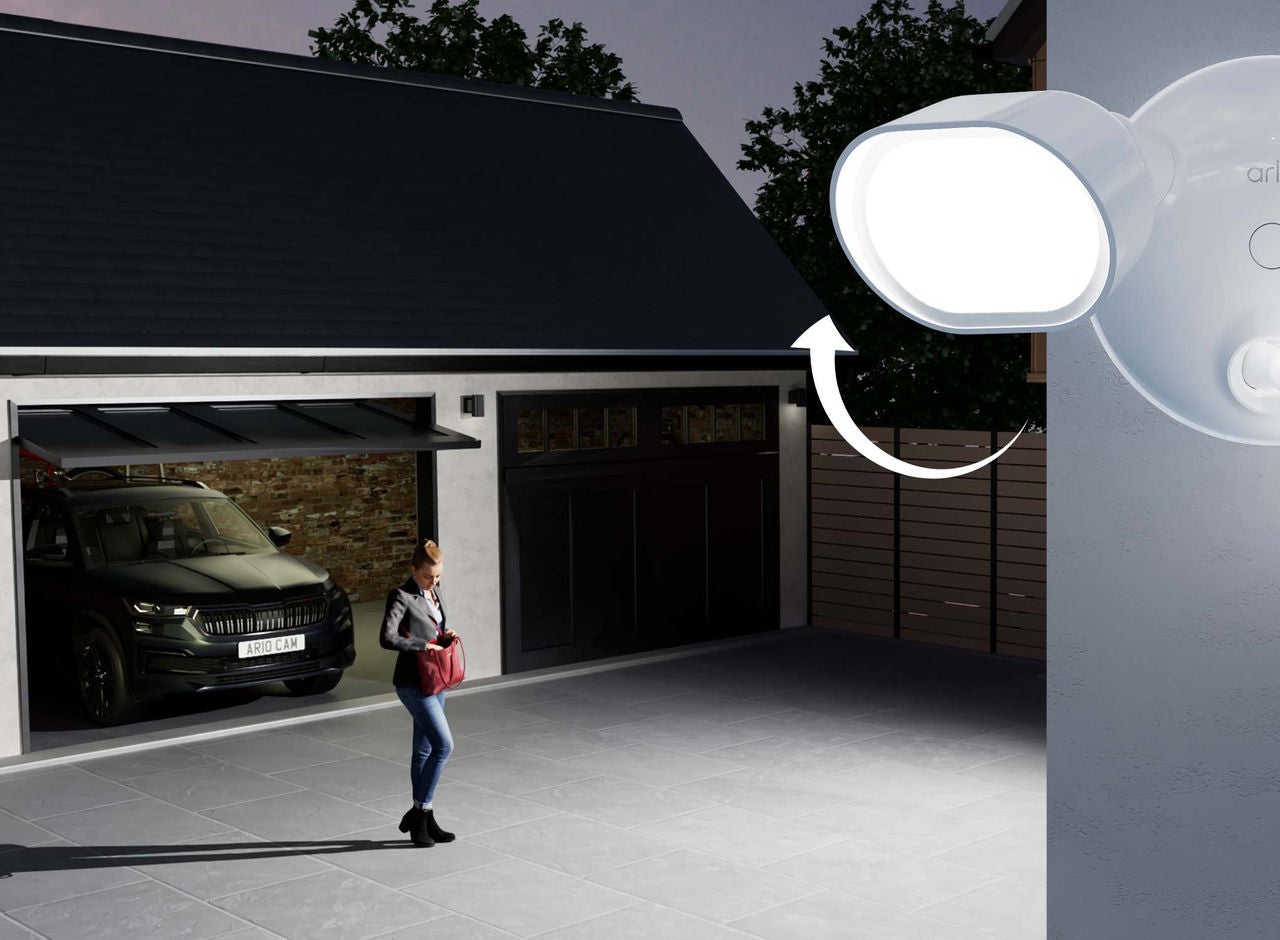 Arlo Floodlight övervakningskamera kopplad till ett hus fångar en man utanför en öppen garageport