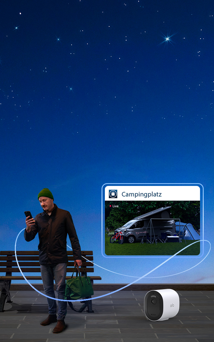 Mann schaut auf sein Handy und beobachtet Live-Übertragung aus dem Wohnwagen