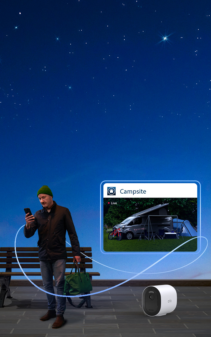 a man holding a phone in his hand to watch his campsite on a security camera video